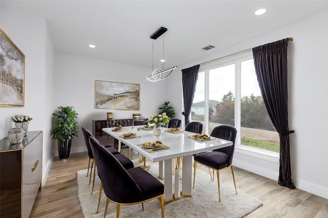 dining room featuring a wealth of natural light, light hardwood / wood-style floors, and an inviting chandelier