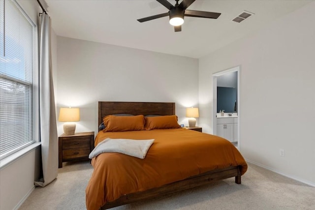 808 Beacon Hts, Seguin, TX 78155 - bedroom featuring light colored carpet, baseboards, ensuite bath, and ceiling fan