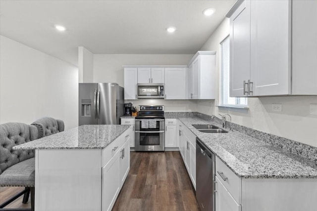 808 Beacon Hts, Seguin, TX 78155 - kitchen with stainless steel appliances, a sink, white cabinetry, a kitchen island, and light stone counters