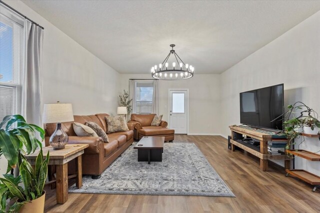 living room with hardwood / wood-style floors and a notable chandelier