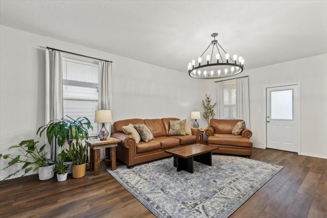 living room with a notable chandelier and dark hardwood / wood-style floors