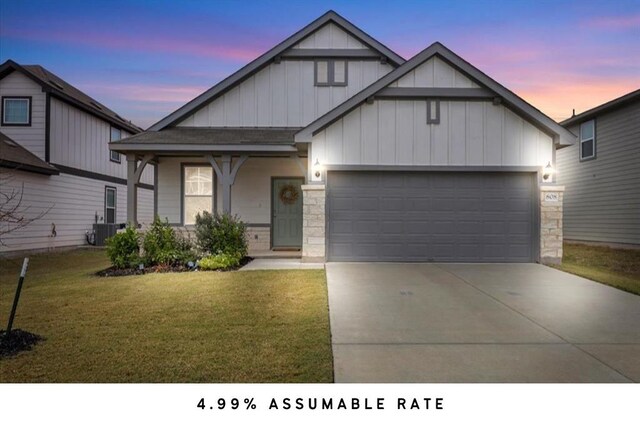 view of front of property with a porch, a garage, central AC, and a yard