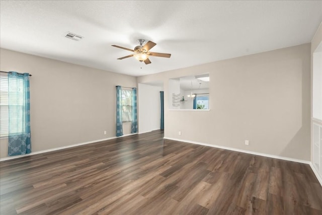 spare room with ceiling fan, plenty of natural light, and dark hardwood / wood-style floors