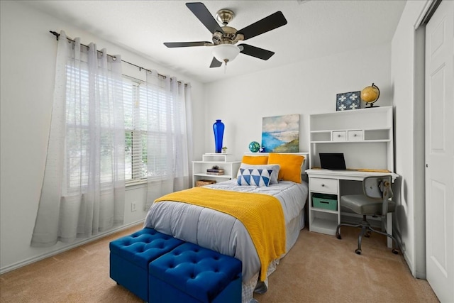 bedroom featuring a closet, light colored carpet, and ceiling fan