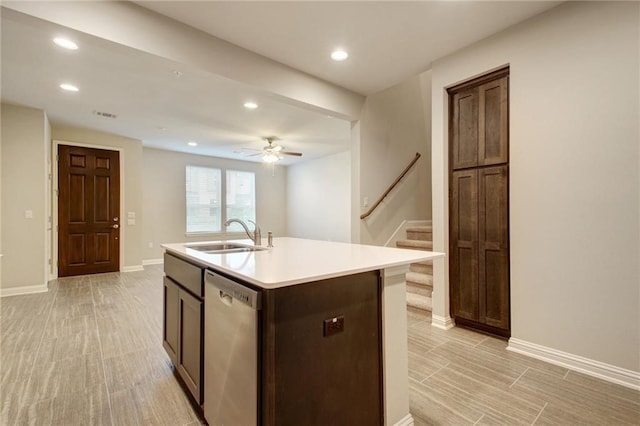 kitchen featuring dishwasher, a center island with sink, sink, ceiling fan, and light hardwood / wood-style floors