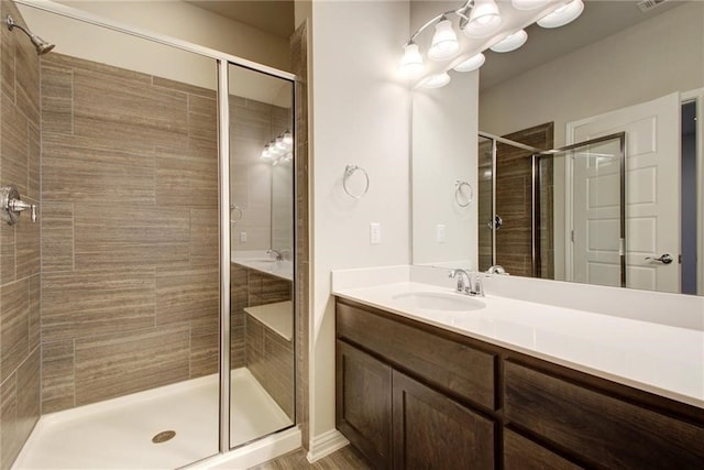 bathroom with vanity and a shower with shower door