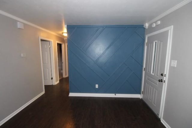 empty room with dark hardwood / wood-style flooring and crown molding