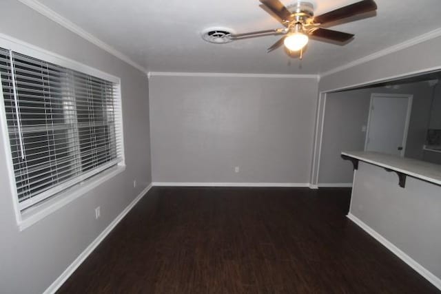 spare room with dark hardwood / wood-style floors, ceiling fan, and crown molding