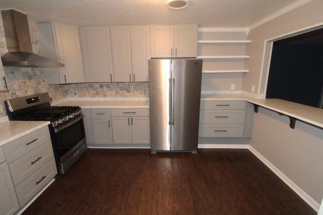 kitchen featuring backsplash, wall chimney exhaust hood, appliances with stainless steel finishes, dark hardwood / wood-style flooring, and white cabinetry