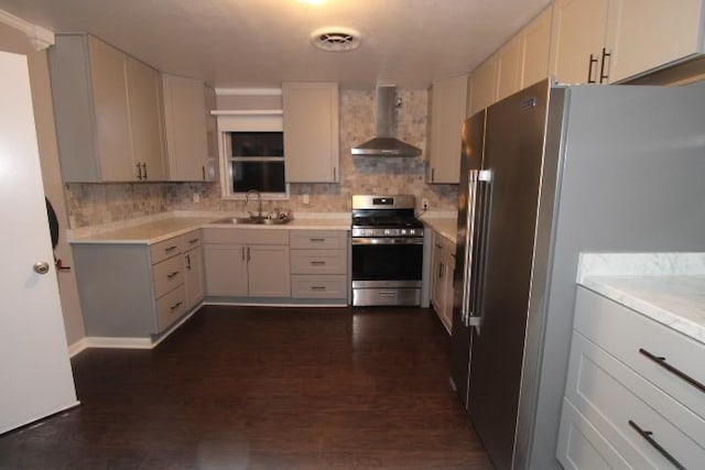 kitchen with white cabinets, appliances with stainless steel finishes, wall chimney exhaust hood, and sink