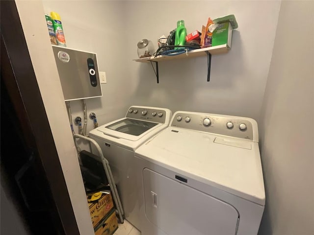 clothes washing area featuring washing machine and dryer and light tile patterned flooring