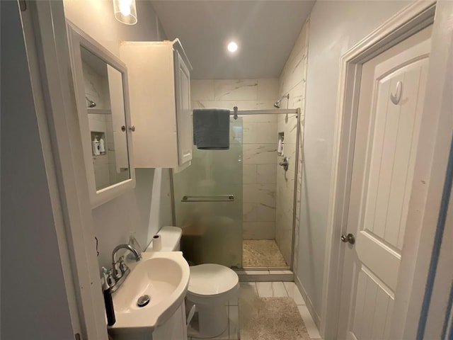 bathroom featuring tile patterned floors, toilet, a shower with door, and sink