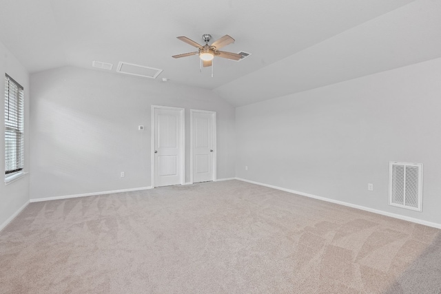 empty room with ceiling fan, light carpet, and vaulted ceiling