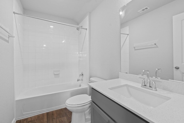 full bathroom with hardwood / wood-style flooring, vanity, toilet, and tiled shower / bath