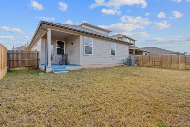 back of property with a yard and central air condition unit