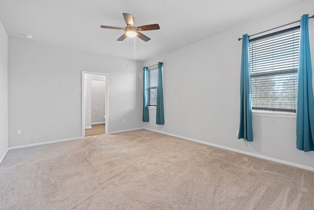 spare room featuring ceiling fan and light colored carpet