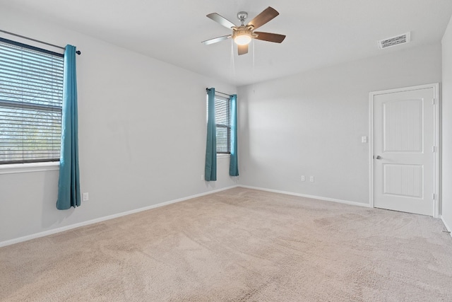 carpeted spare room with ceiling fan