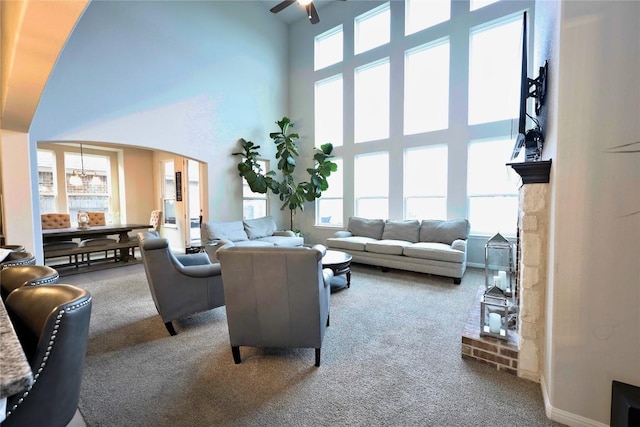 living room with a towering ceiling, carpet floors, and a wealth of natural light