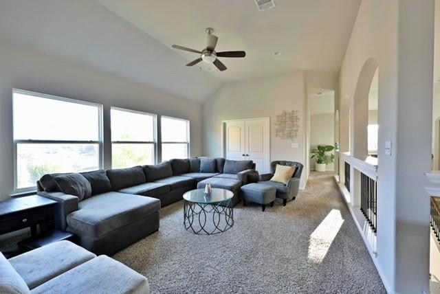 living room featuring carpet flooring, ceiling fan, and high vaulted ceiling