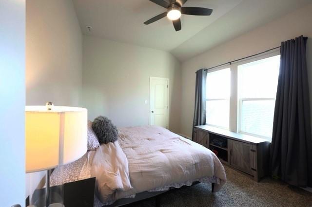 carpeted bedroom featuring ceiling fan and vaulted ceiling