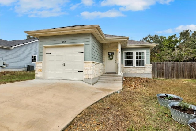 view of front of home with a garage and central air condition unit