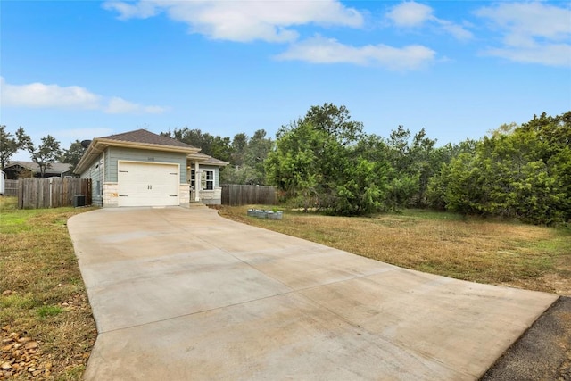 view of front of property with a front yard, central AC, and a garage