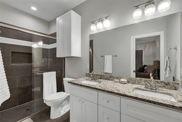 bathroom with a shower with door, vanity, and toilet