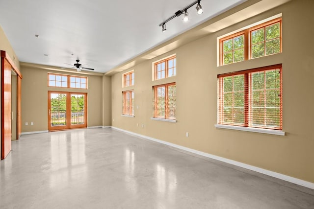 empty room featuring ceiling fan, french doors, and rail lighting