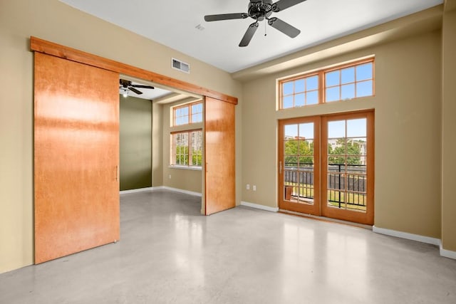 empty room featuring ceiling fan, french doors, and a healthy amount of sunlight