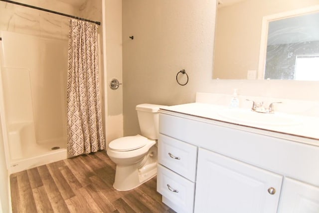 bathroom featuring a shower with shower curtain, vanity, hardwood / wood-style flooring, and toilet