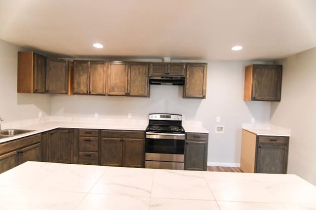 kitchen featuring dark brown cabinetry, sink, stainless steel stove, and light hardwood / wood-style flooring