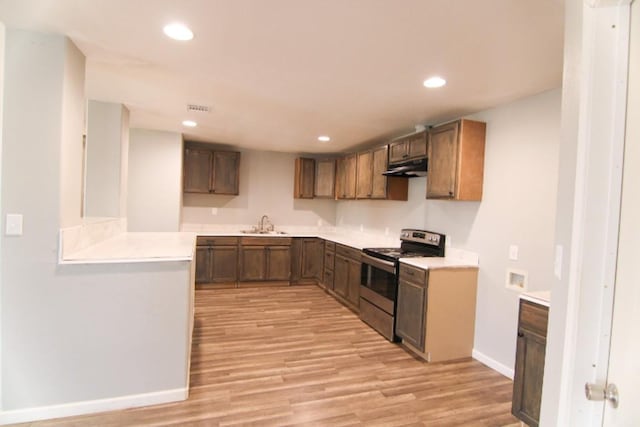 kitchen with electric stove, sink, and light wood-type flooring