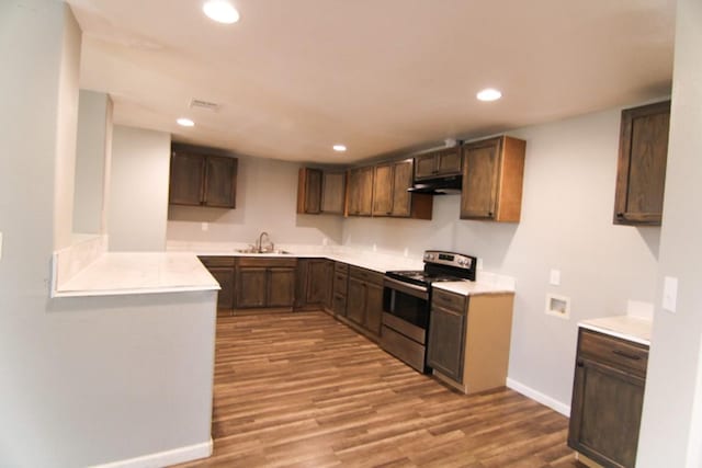 kitchen featuring dark brown cabinetry, electric range, sink, and light wood-type flooring