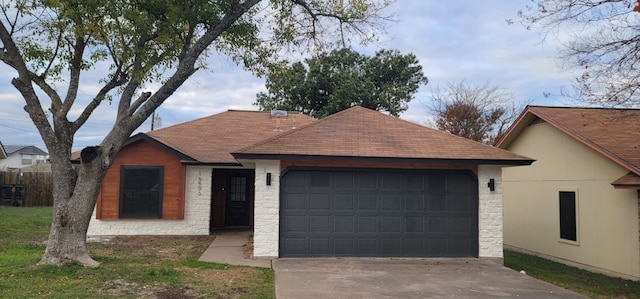 ranch-style house featuring a garage and a front lawn