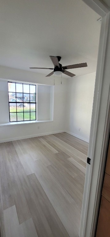 empty room with ceiling fan and light wood-type flooring