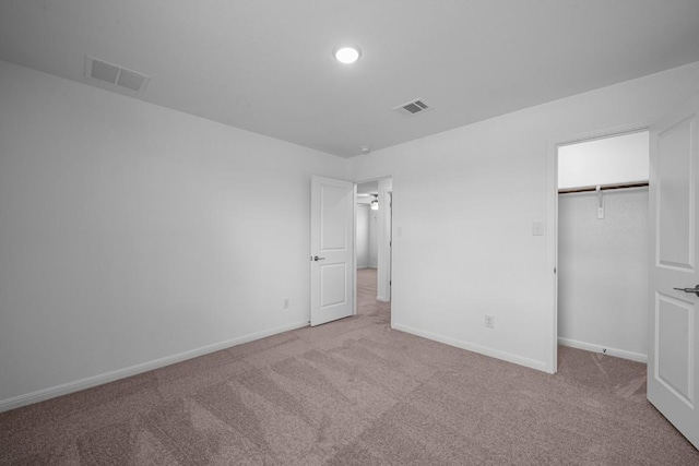 unfurnished bedroom featuring light carpet and a closet