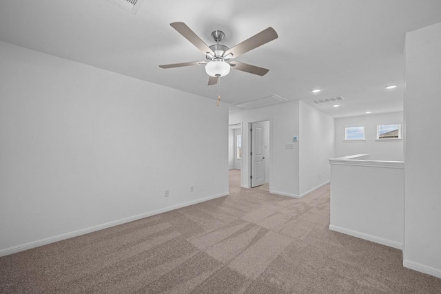 unfurnished room featuring light colored carpet and ceiling fan