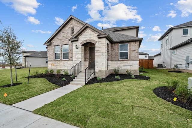 view of front of home with a front lawn and central air condition unit