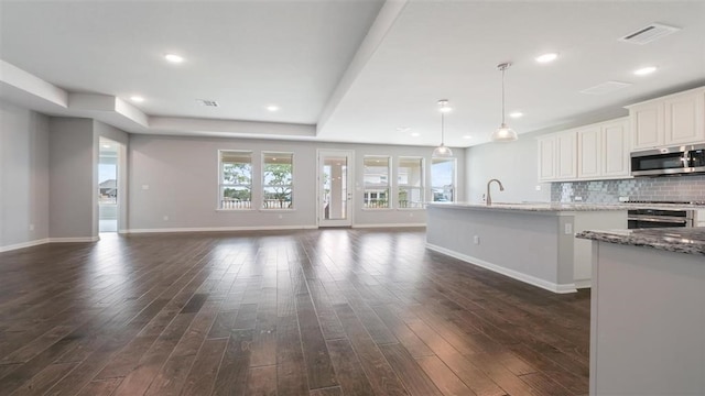 unfurnished living room with dark hardwood / wood-style flooring and sink