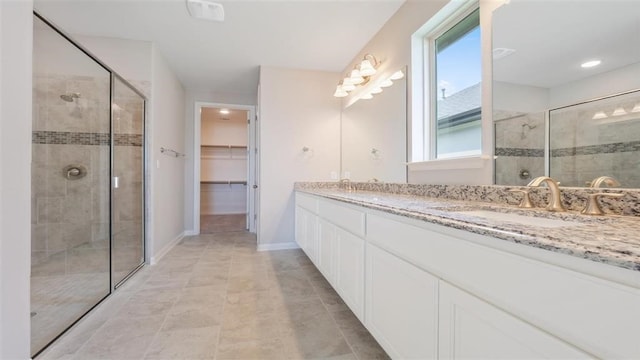 bathroom featuring tile patterned floors, vanity, and a shower with door