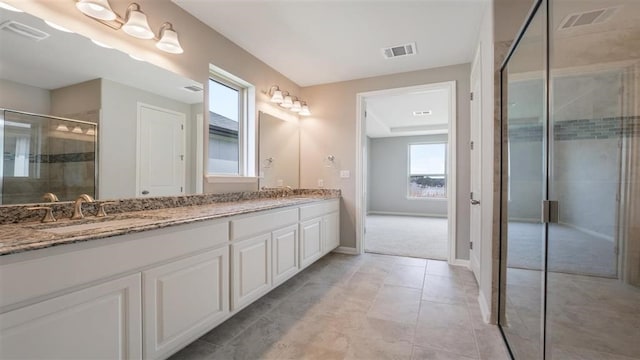 bathroom with tile patterned floors, vanity, and an enclosed shower