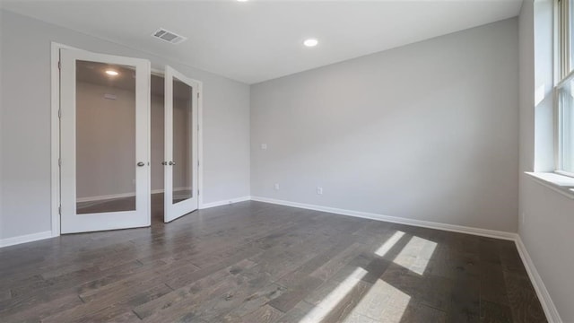 spare room featuring dark hardwood / wood-style floors and french doors