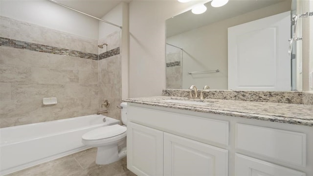 full bathroom featuring tile patterned floors, vanity, tiled shower / bath combo, and toilet