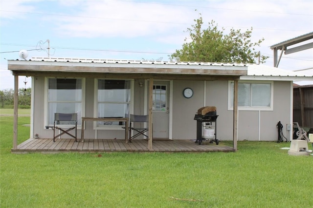 rear view of property featuring a lawn and a deck