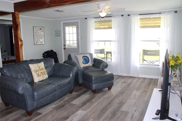 living room with ceiling fan, crown molding, beamed ceiling, and light hardwood / wood-style floors