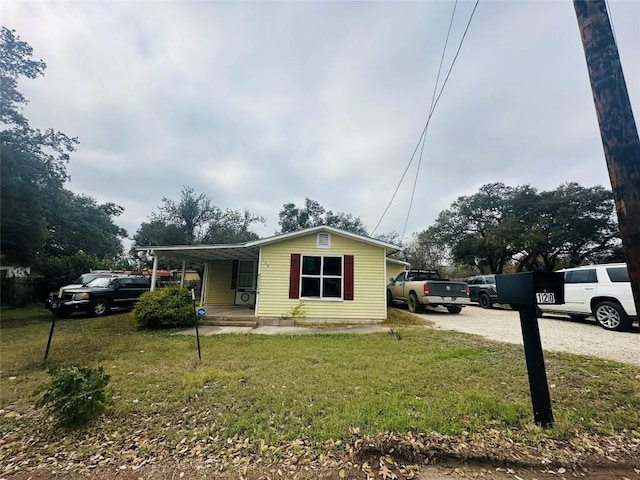 view of front of house featuring a front lawn and a carport