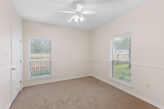 carpeted spare room with ceiling fan and a healthy amount of sunlight