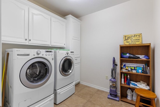 washroom with washer and dryer, light tile patterned floors, and cabinets