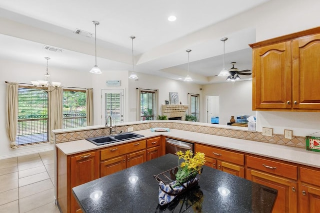 kitchen with stainless steel dishwasher, ceiling fan with notable chandelier, sink, and a wealth of natural light