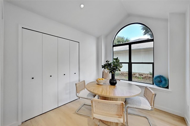 dining space featuring light hardwood / wood-style floors and lofted ceiling